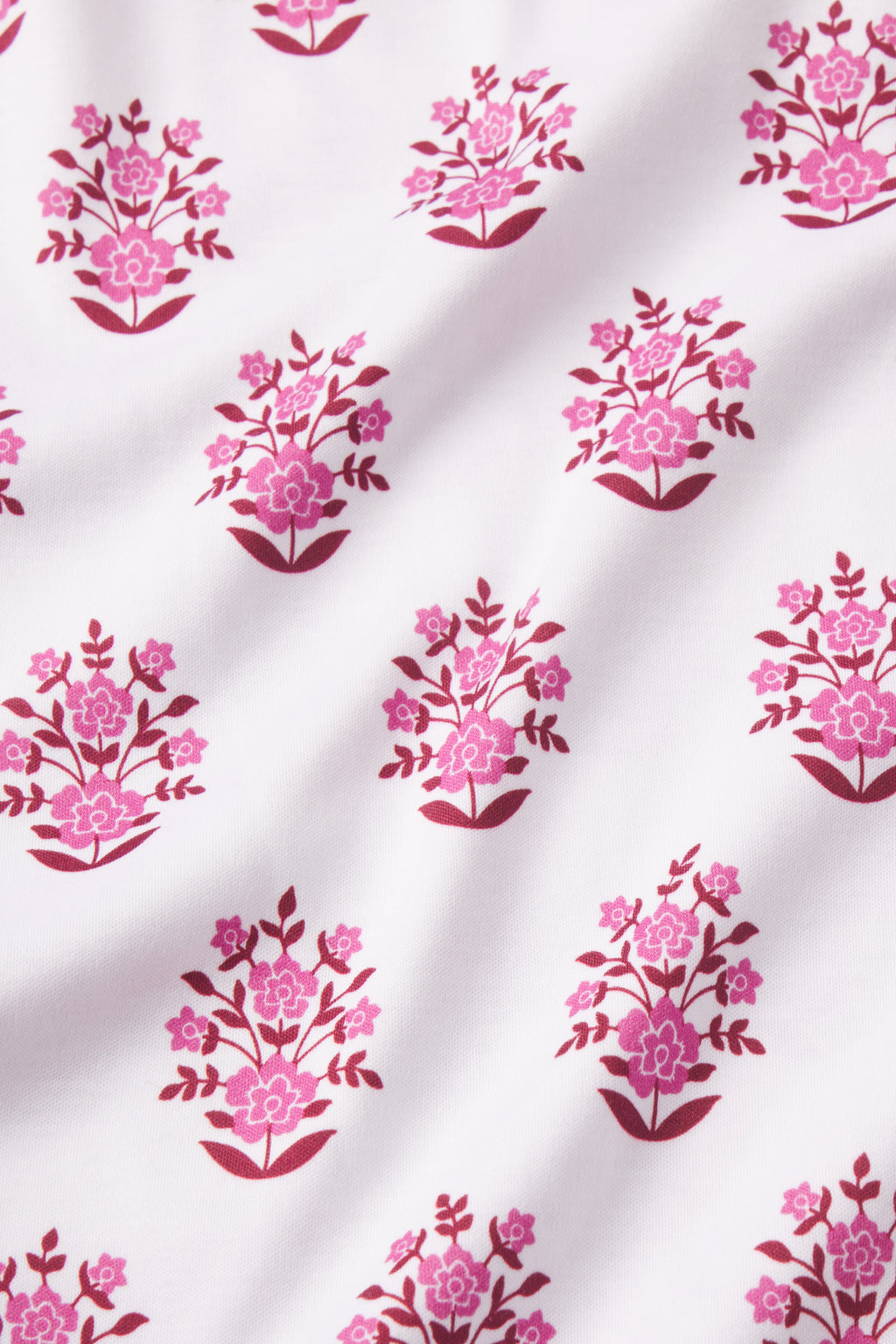 The Pima Crew Short-Long Set in Cabernet Cottage Floral features white Pima cotton fabric with small pink floral block print bouquets in vases, arranged in neat rows, creating a soft, elegant look.