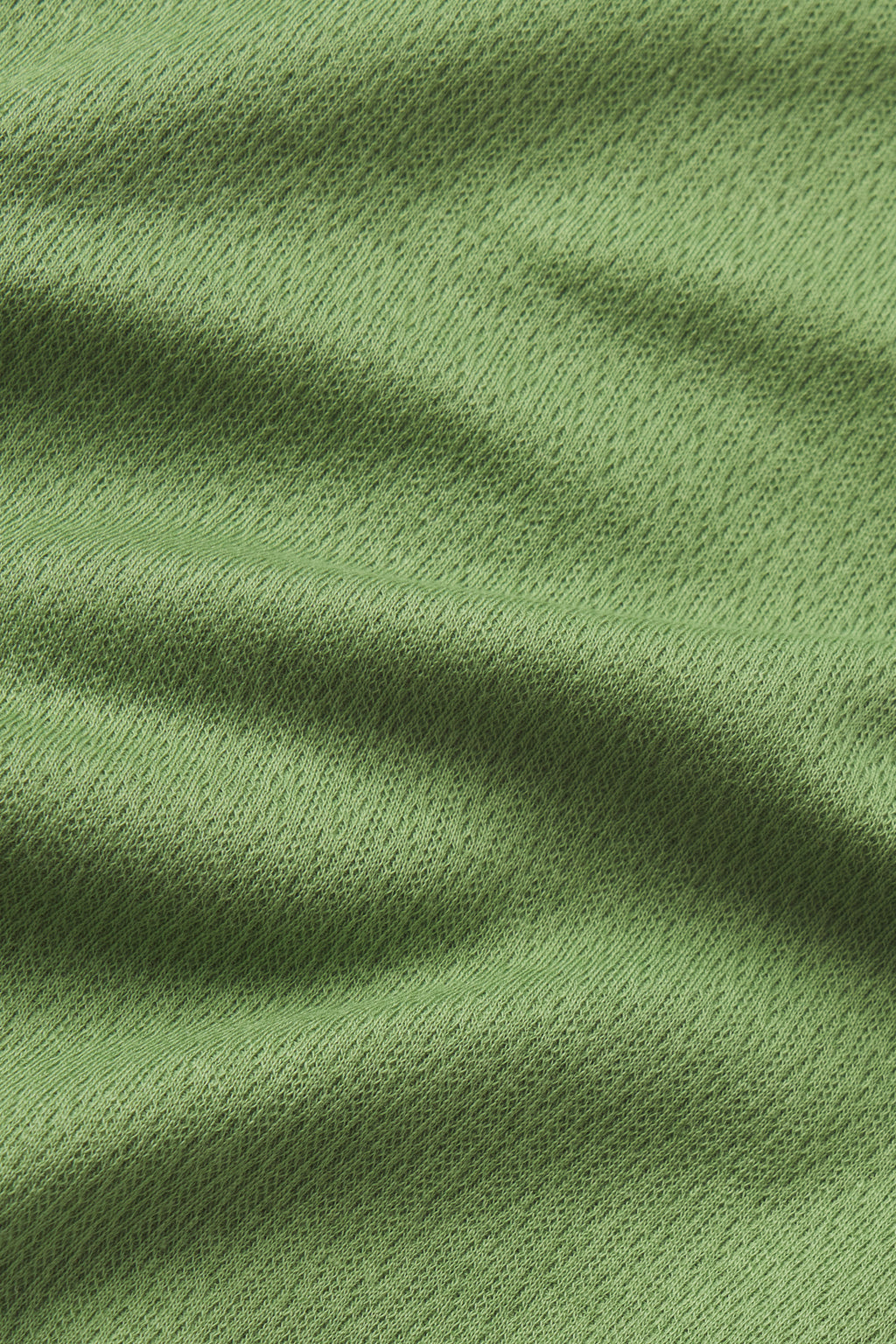 Close-up of the Pointelle Pajama Pants Set in Willow Bough, featuring light green fabric with a subtle dotted texture and visible folds—lightweight knit ideal for hot sleepers seeking cool comfort.