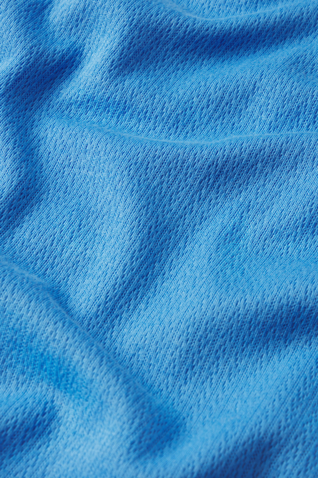 Close-up of the Pointelle Shorts Bundle in Regatta shows textured blue Pima cotton with a visible weave and gentle folds, creating a soft, smooth look.