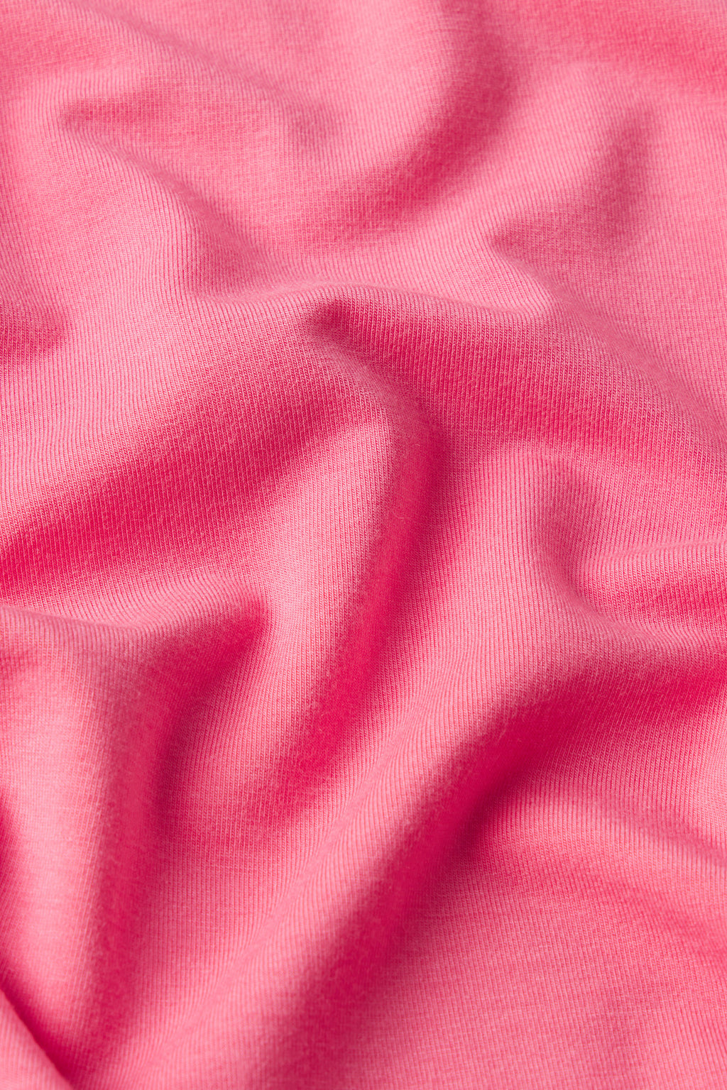 Close-up of the DreamModal Cami Nightgown in Sunkissed Coral, showing soft folds and gentle creases on its smooth, subtly textured fabric.