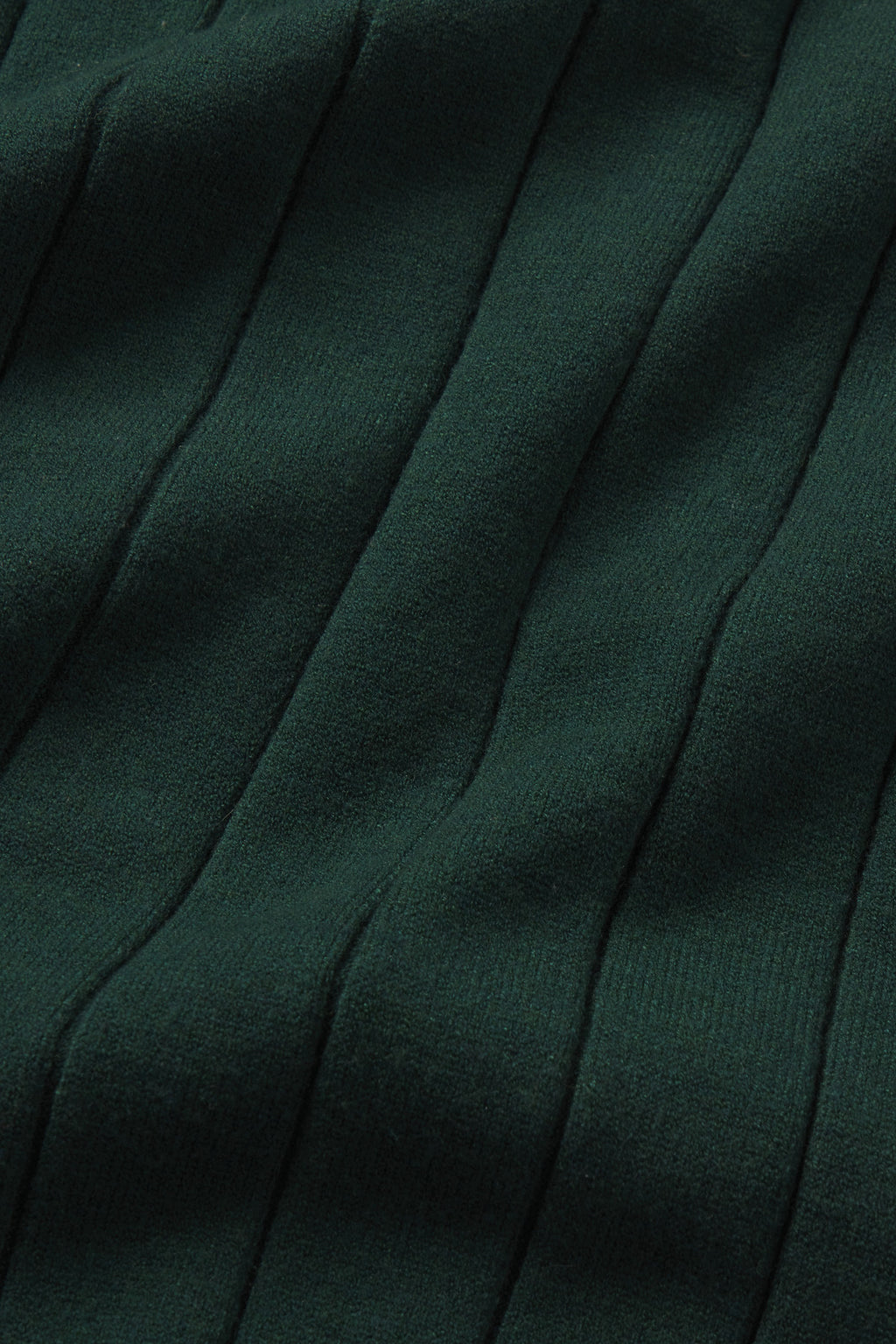 Close-up of dark green ribbed fabric with vertical textured lines and soft folds, featured in the cozy Vesper Jogger Set in Conifer.