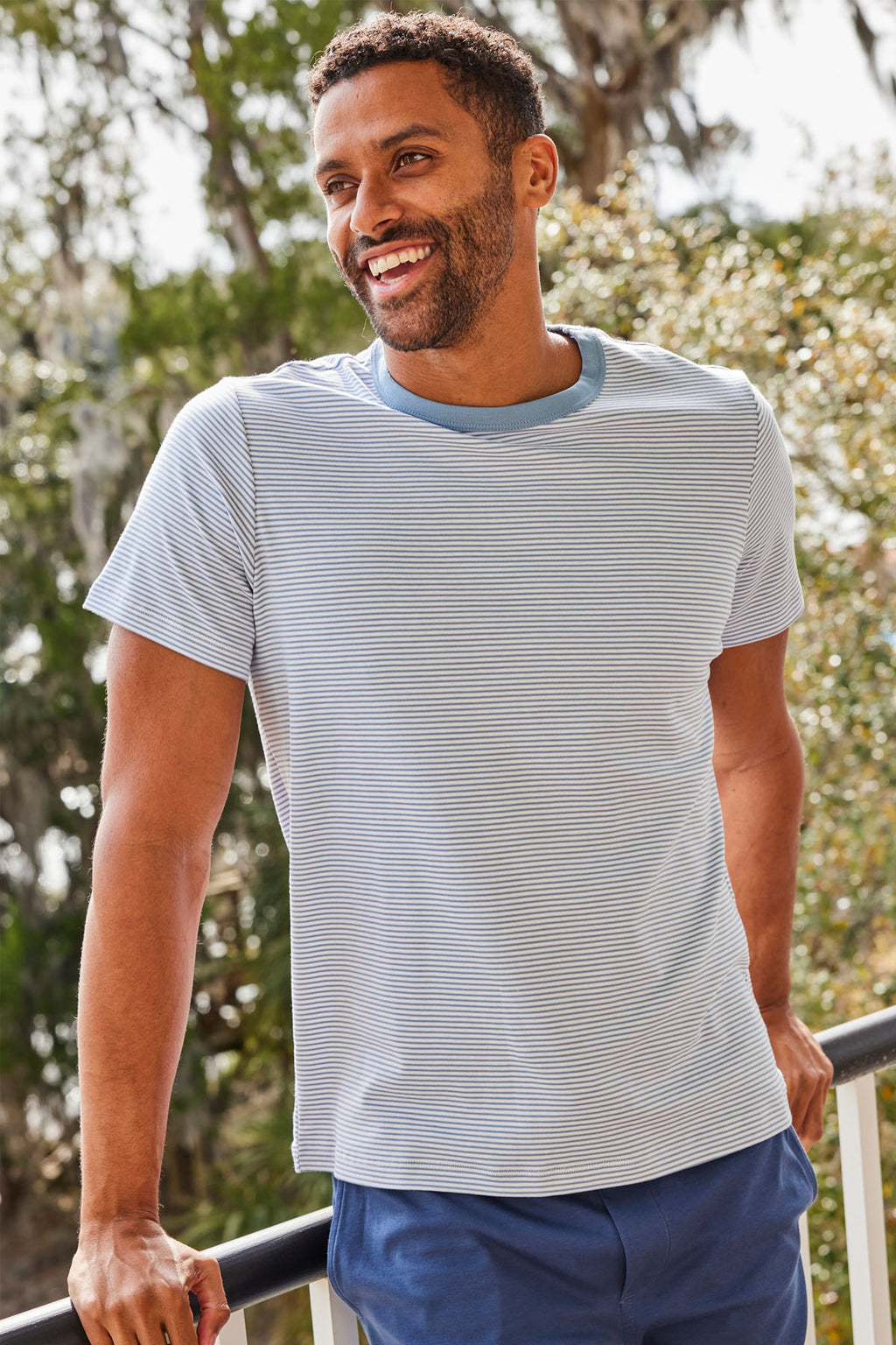 Man wearing anchor blue and white striped crewneck t-shirt with short sleeves.