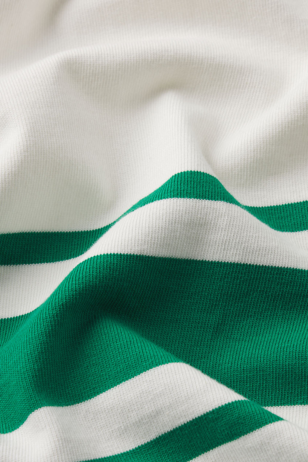 Close-up of the Runaround Dress in Lush Santorini Stripe, highlighting the texture and soft folds of its green and white striped fabric.