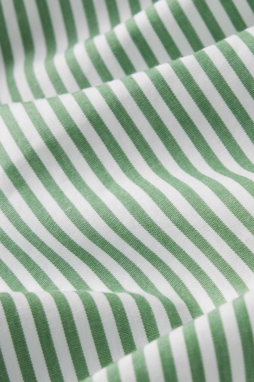 Close-up of fabric from the Poplin Piped Long-Short Set in Palm Riviera Stripe, showcasing green and white diagonal stripes with soft folds and a smooth poplin texture.