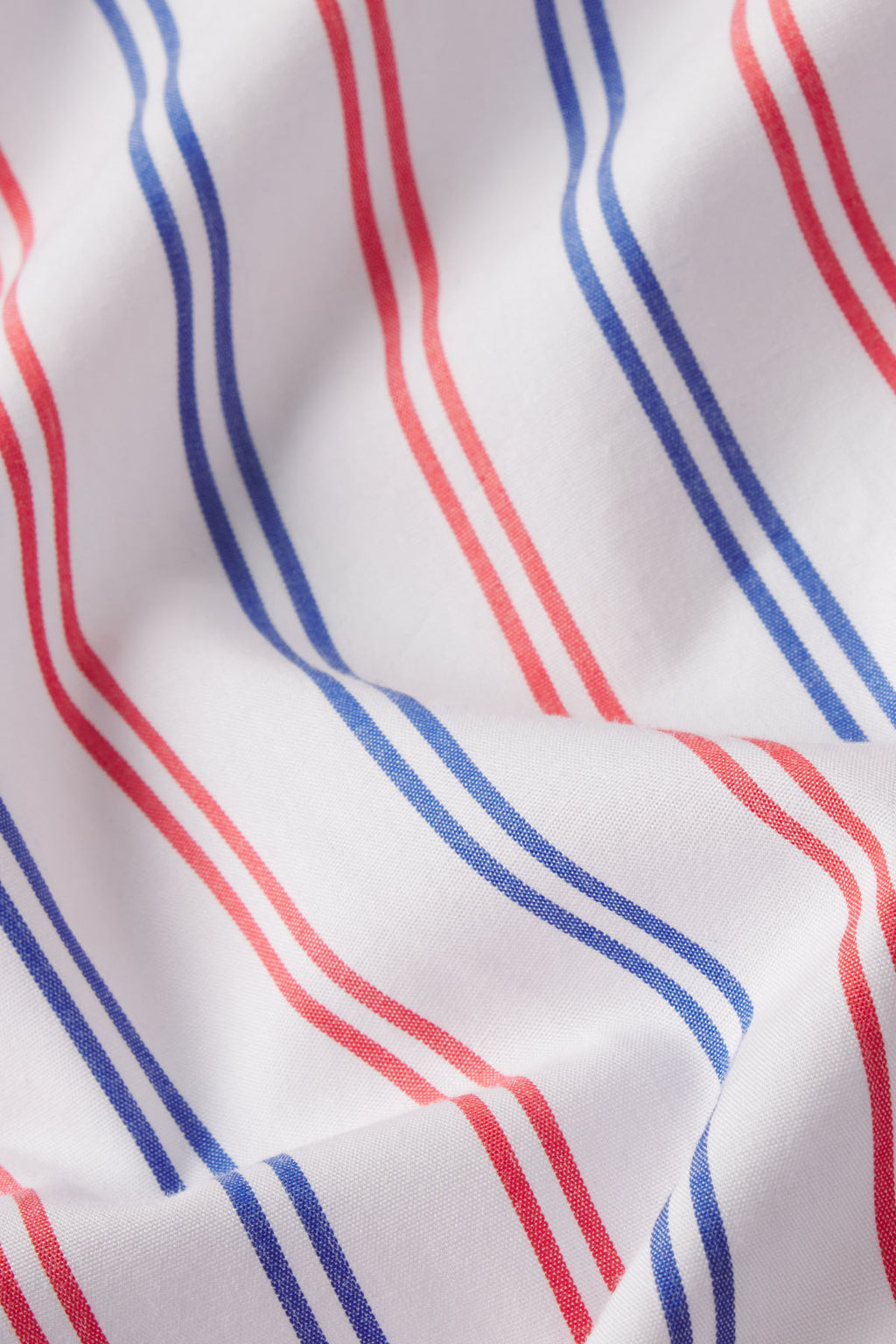 White poplin fabric with alternating vertical stripes in navy and coral pink.