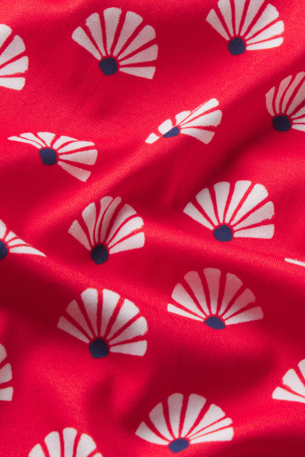 Bright pink fabric with repeating white and gray scallop shell pattern with navy centers.