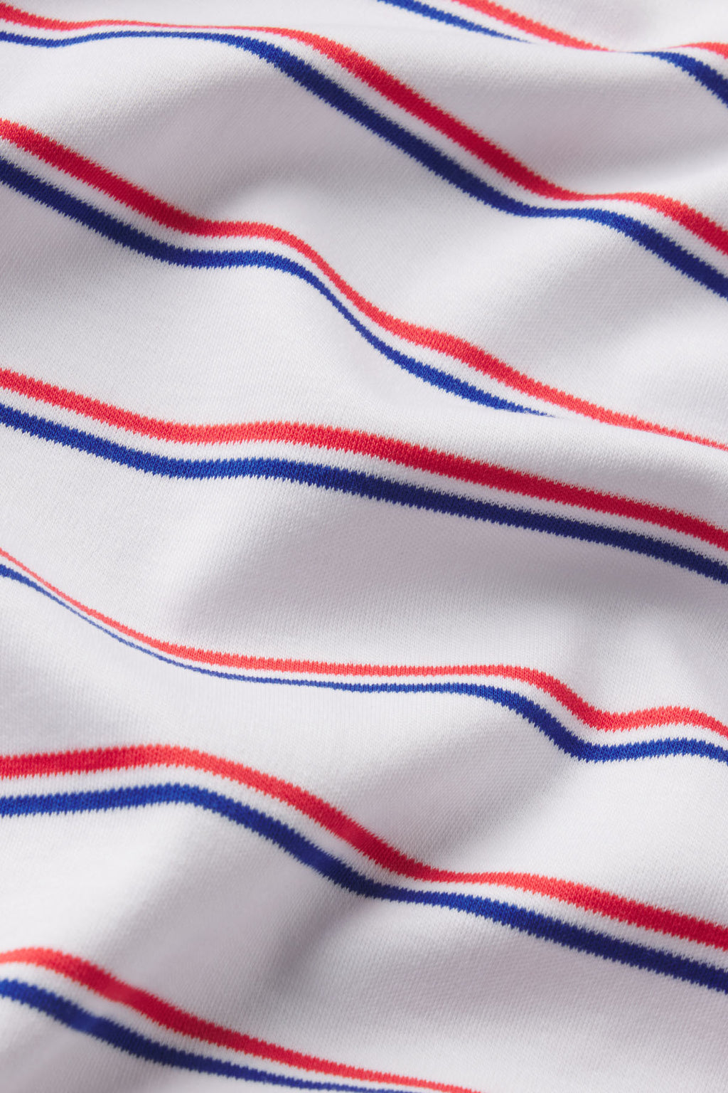 White knit fabric with diagonal stripes in navy blue and coral pink.