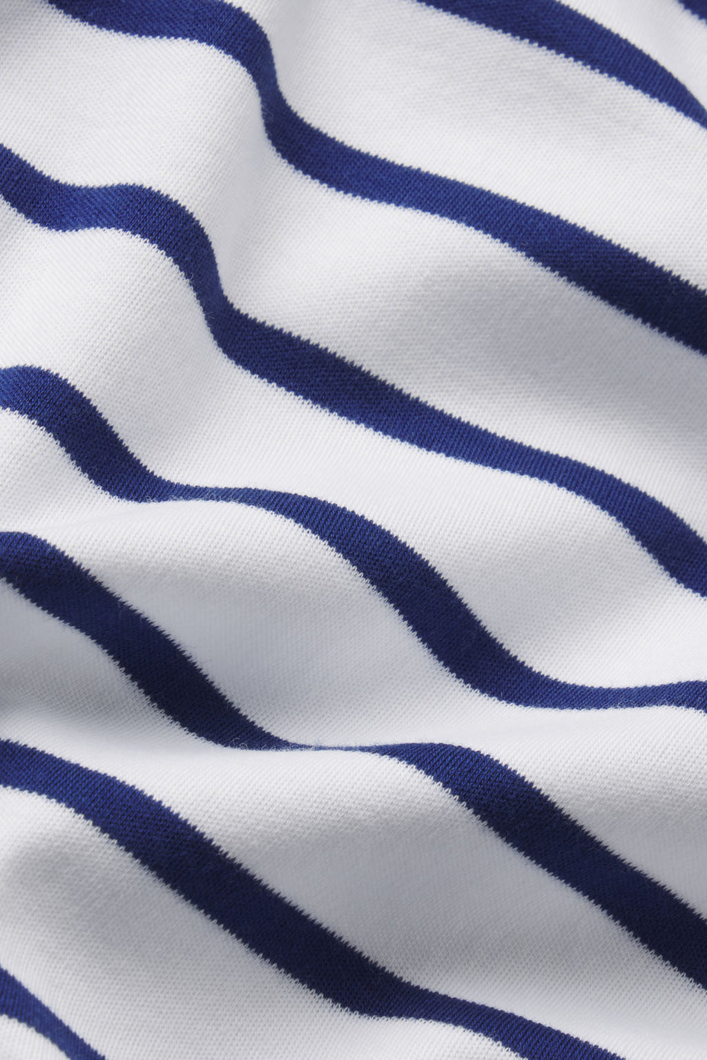 A close-up of the Pima Bundle in Blue Depths Anchor Stripe, showing soft Pima cotton fabric with evenly spaced horizontal navy and white stripes and gentle folds.