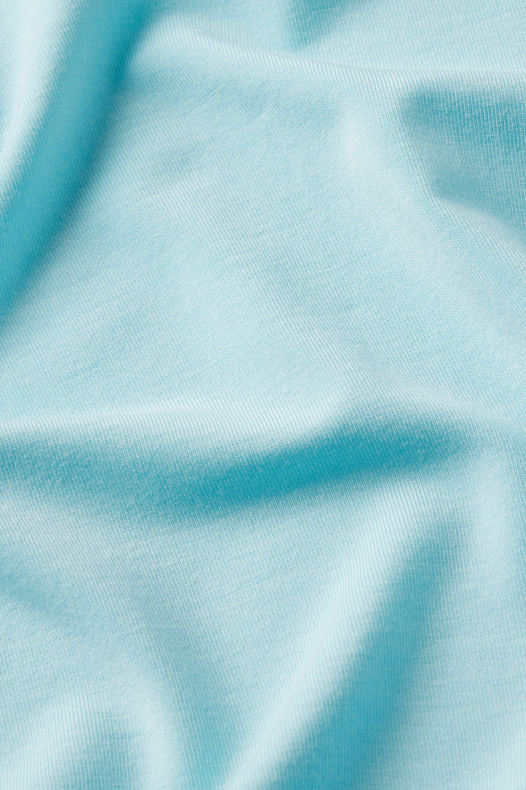 Light blue and white striped ribbed fabric with diagonal folds and texture detail.