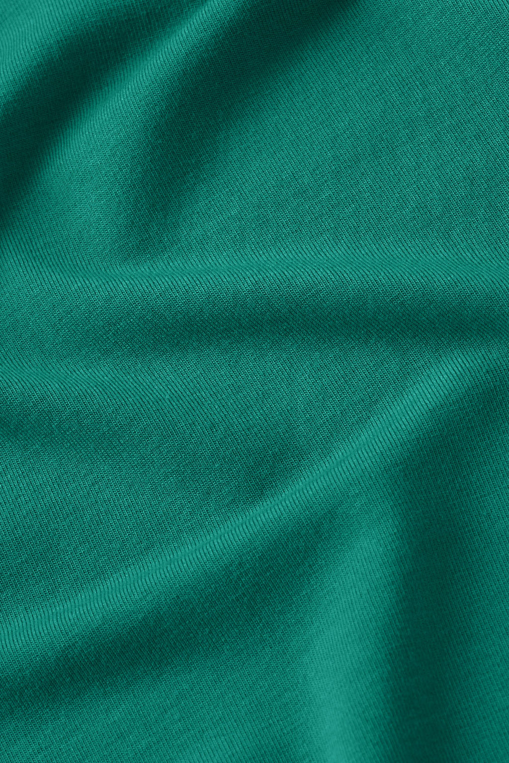 Teal ribbed knit fabric with draped folds showing texture and depth.