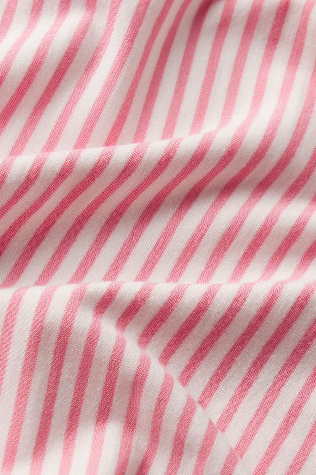 Pink and white striped fabric with soft, diagonal lines and gentle folds, evoking the luxurious DreamModal™ Kimono Pants Bundle in Gelato Pencil Stripe.