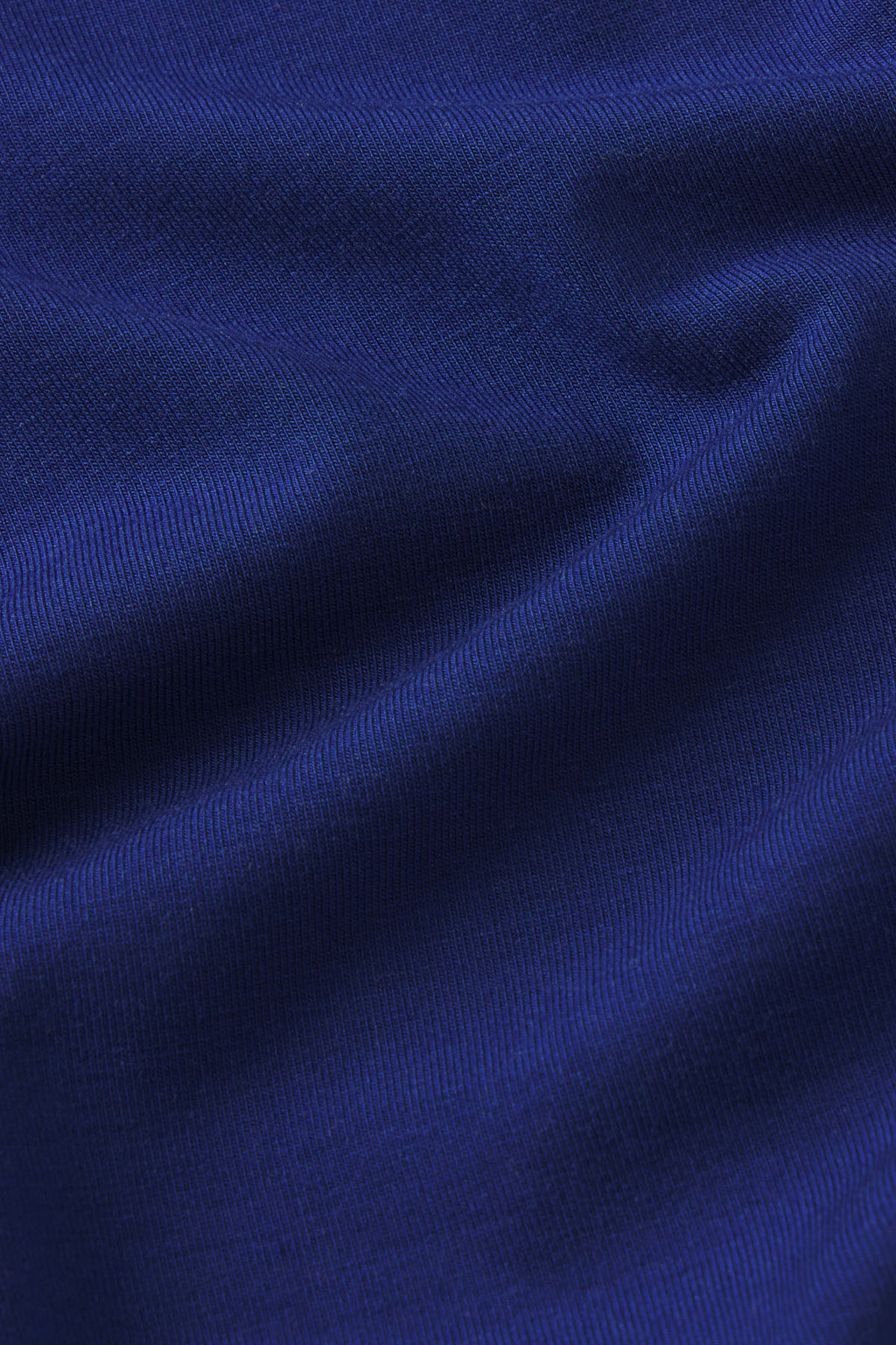 Dark blue ribbed knit fabric with a textured, draped surface.
