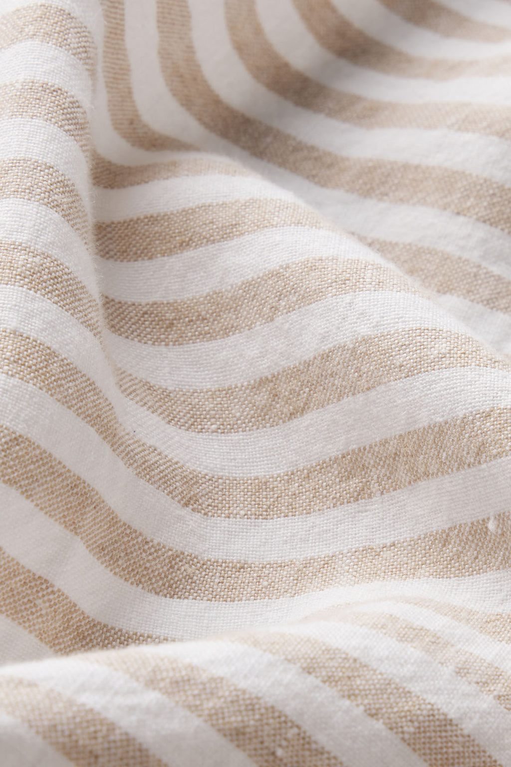 A close-up of the Cruise Short Set in Sandstone Amalfi Stripe shows its beige and white woven stripes with soft, draped folds—perfect inspiration for a chic women’s cruise outfit or stylish striped linen set.
