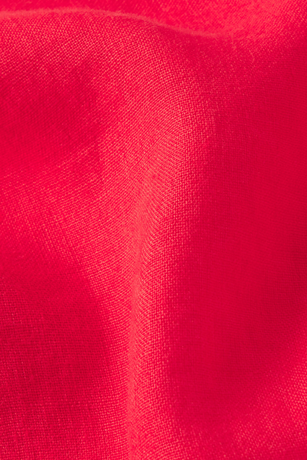 Close-up of bright pink-red fabric with a soft texture and visible weave, featuring gentle folds and shadows—perfect for the Coupe Pant Set in Tart.