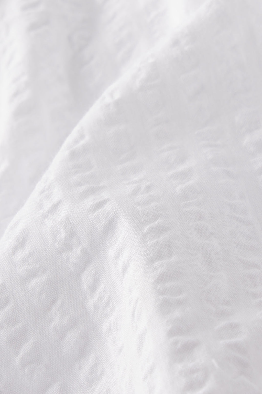 Close-up of the Charlie Shorts Set in White Seersucker, highlighting its softly textured, slightly wrinkled fabric for an airy look and feel.