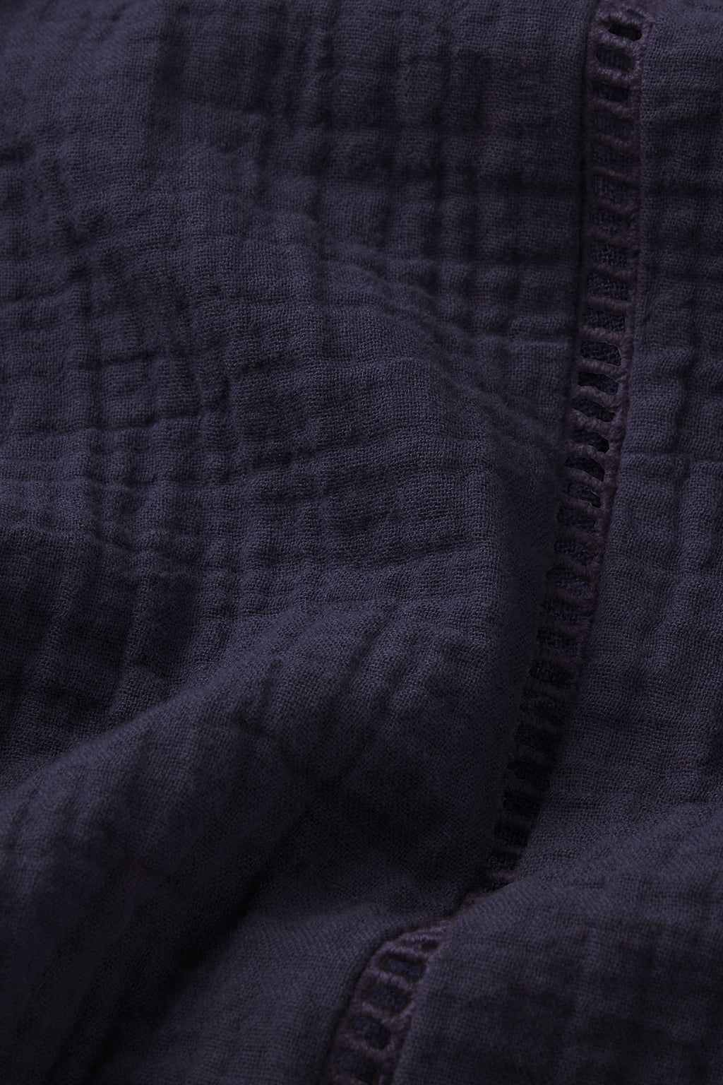 Close-up of the Cabana Skirt Set in Maritime shows its dark purple, soft cotton gauze fabric with a visible vertical stitched seam on the right and a gently wrinkled, airy texture.