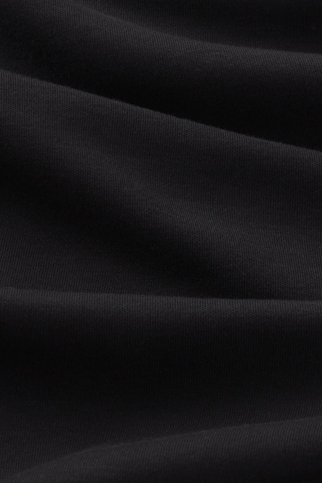 Black t-shirt with ribbed knit texture and relaxed boxy fit.