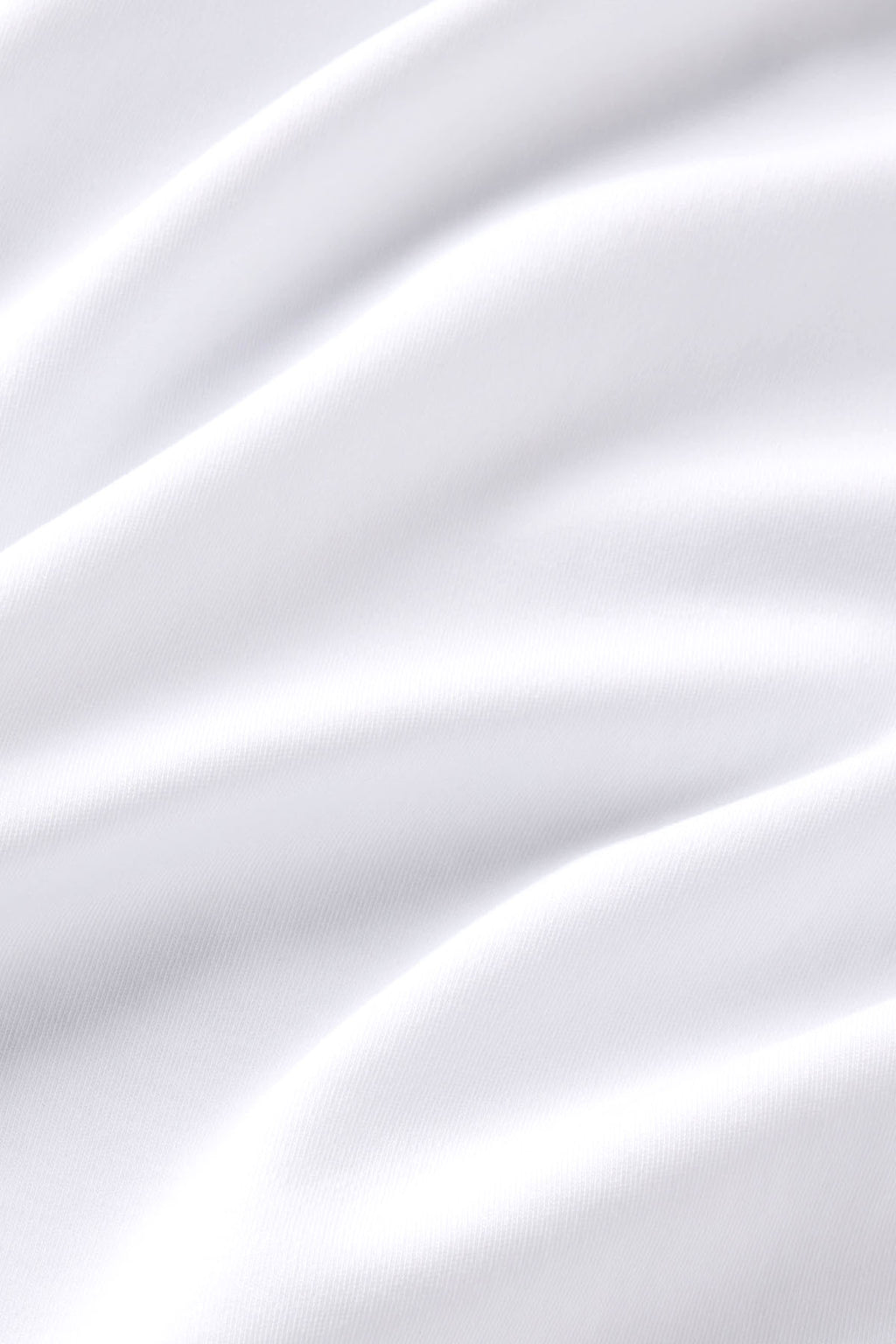 White textured t-shirt fabric with soft folds and shadows showing the material