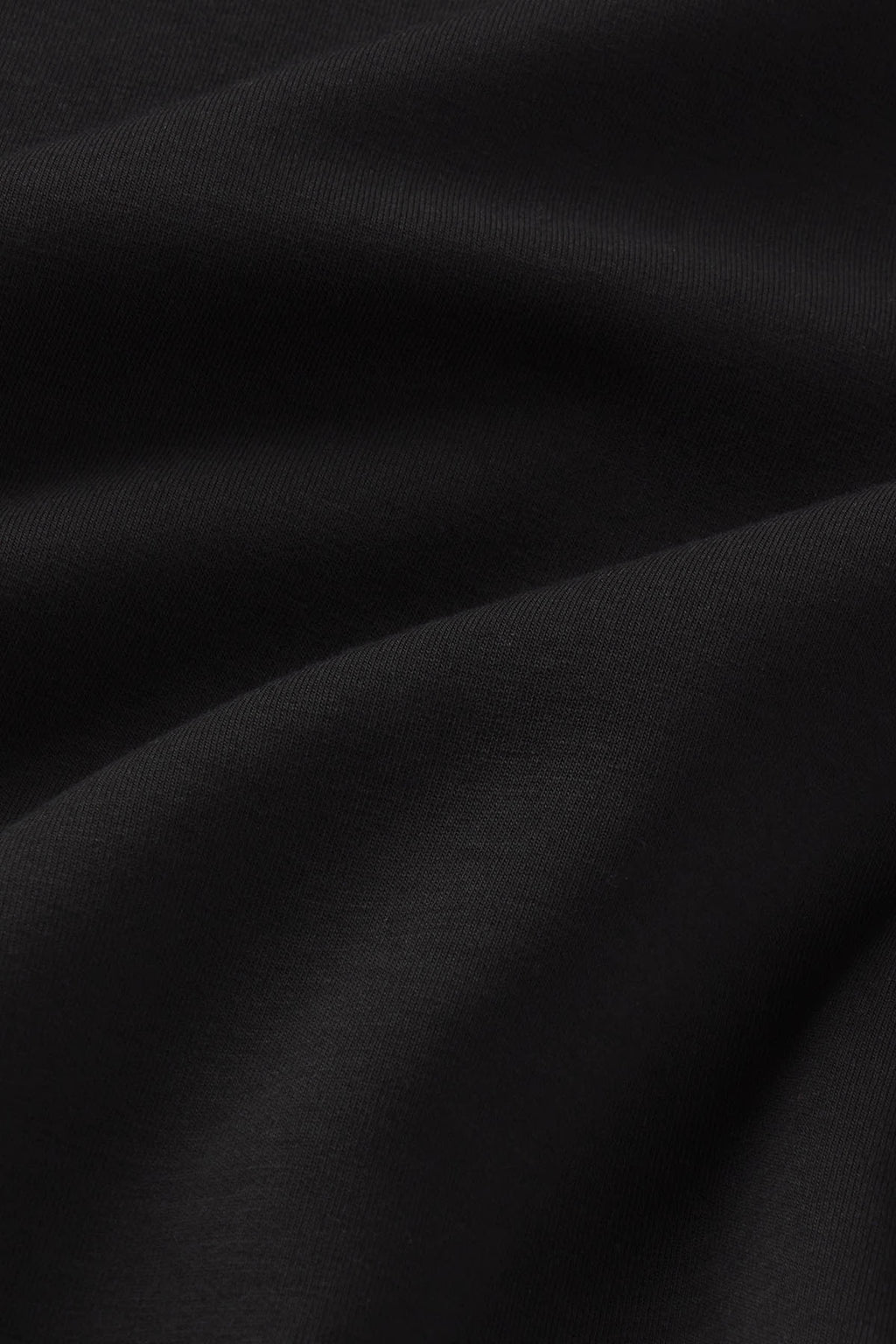 Black ribbed fabric with diagonal folds and texture detail.