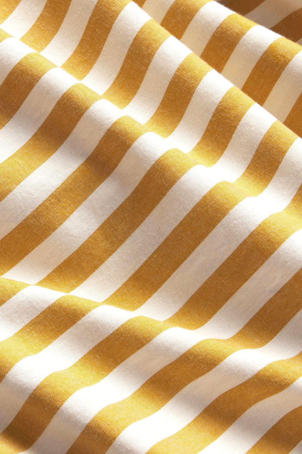 Diagonal striped fabric in gold, cream, and tan tones with textured weave detail.