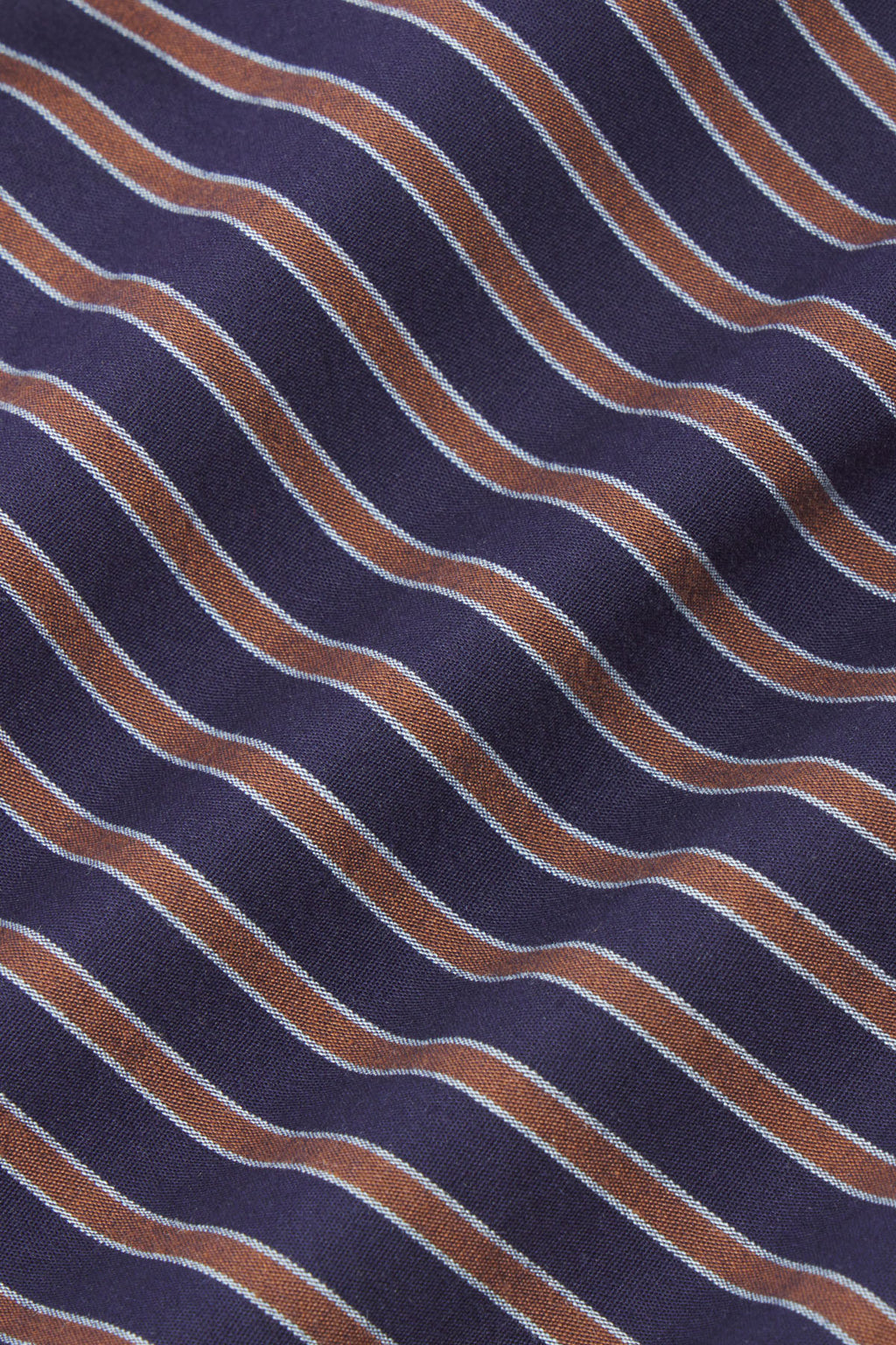 Diagonal striped fabric in navy, tan, and light blue wavy stripes on textured weave.