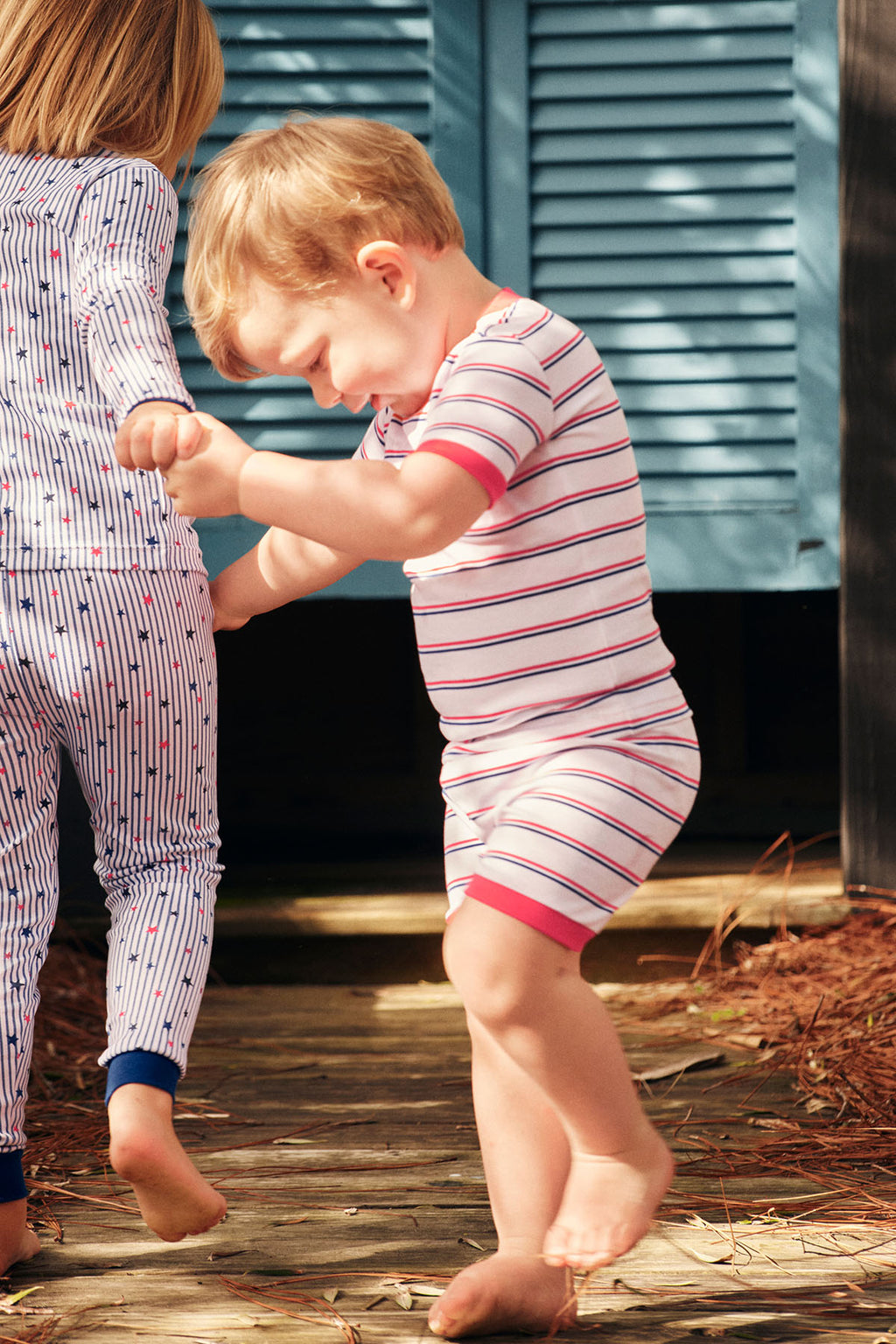 Toddler wearing striped shorts set with red and navy horizontal stripes and matching red waistband.