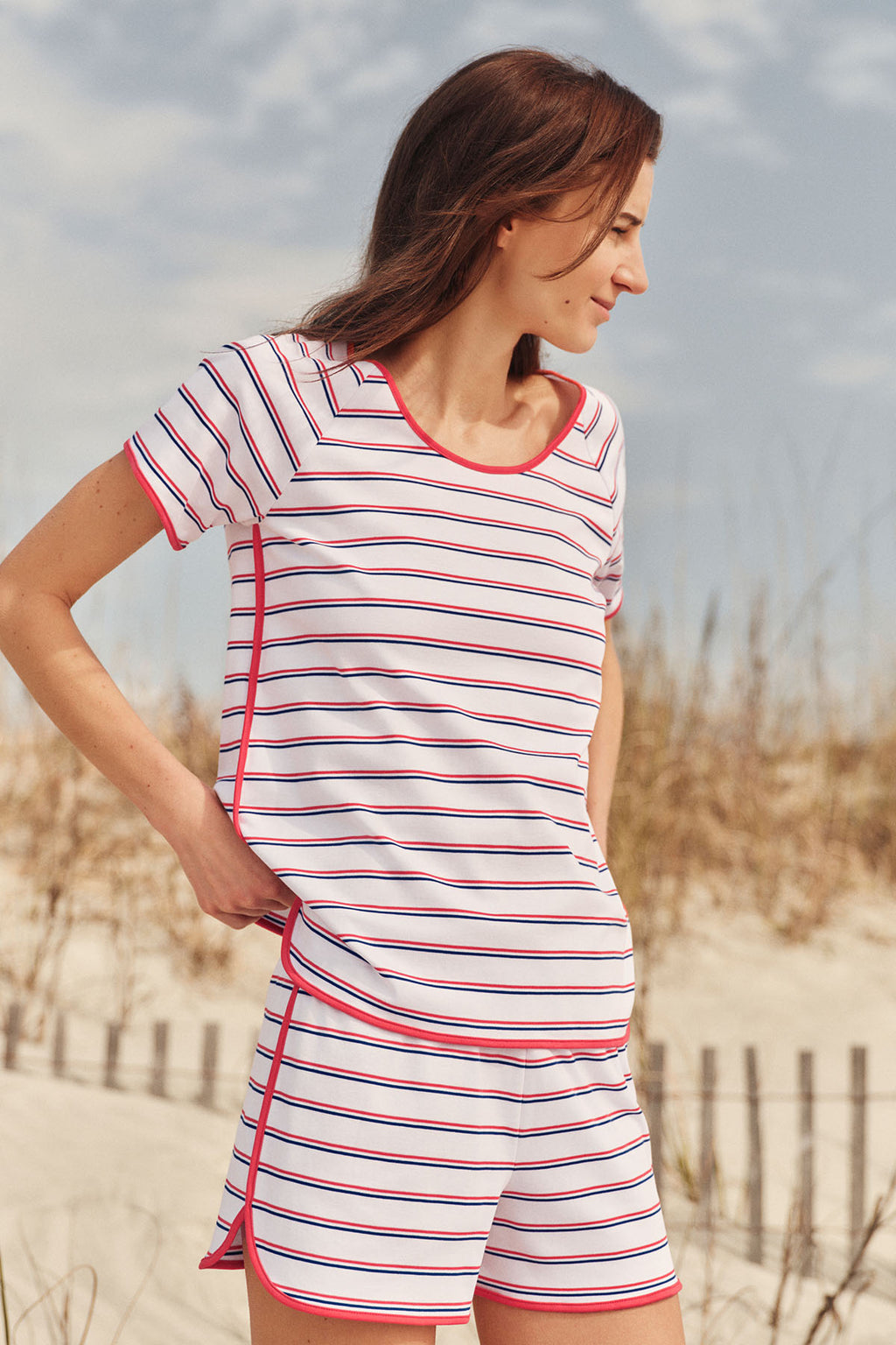 White shorts set with navy and red horizontal stripes and pink trim on neckline and cuffs.
