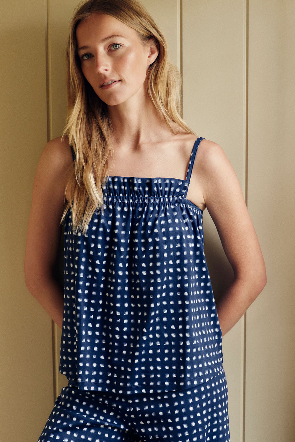 Woman wearing navy blue brushed check pants set with white checkered pattern and ruffle hem detail.