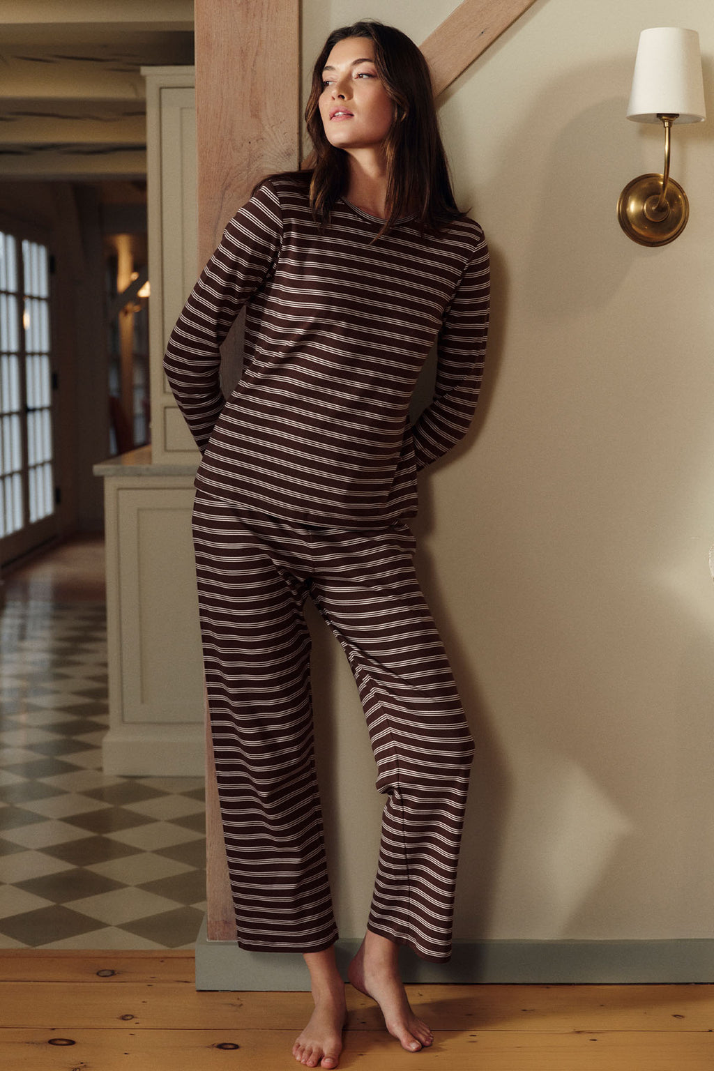 Woman wearing cocoa brown and cream striped long-sleeve crew neck top and matching cropped pants.