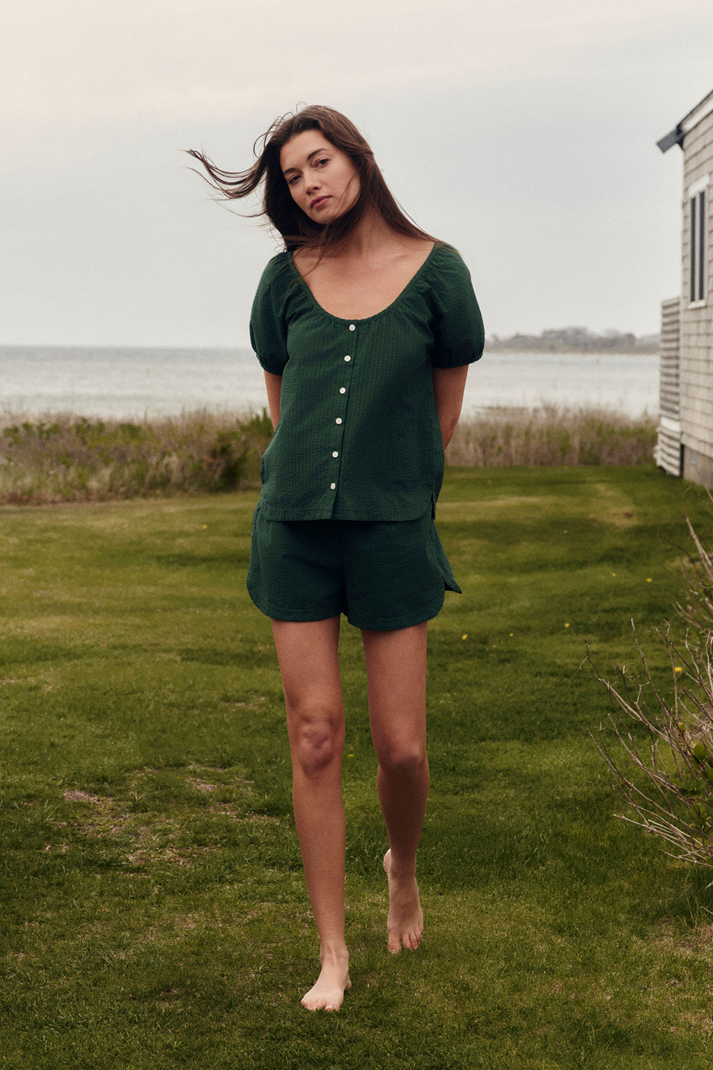 Woman wearing dark green seersucker shorts set with button-front top and matching shorts.