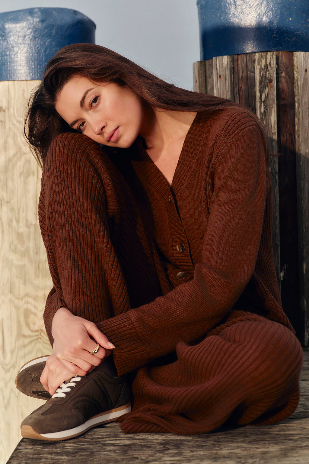 Woman wearing cinnamon ribbed button-front cardigan and matching ribbed pants.