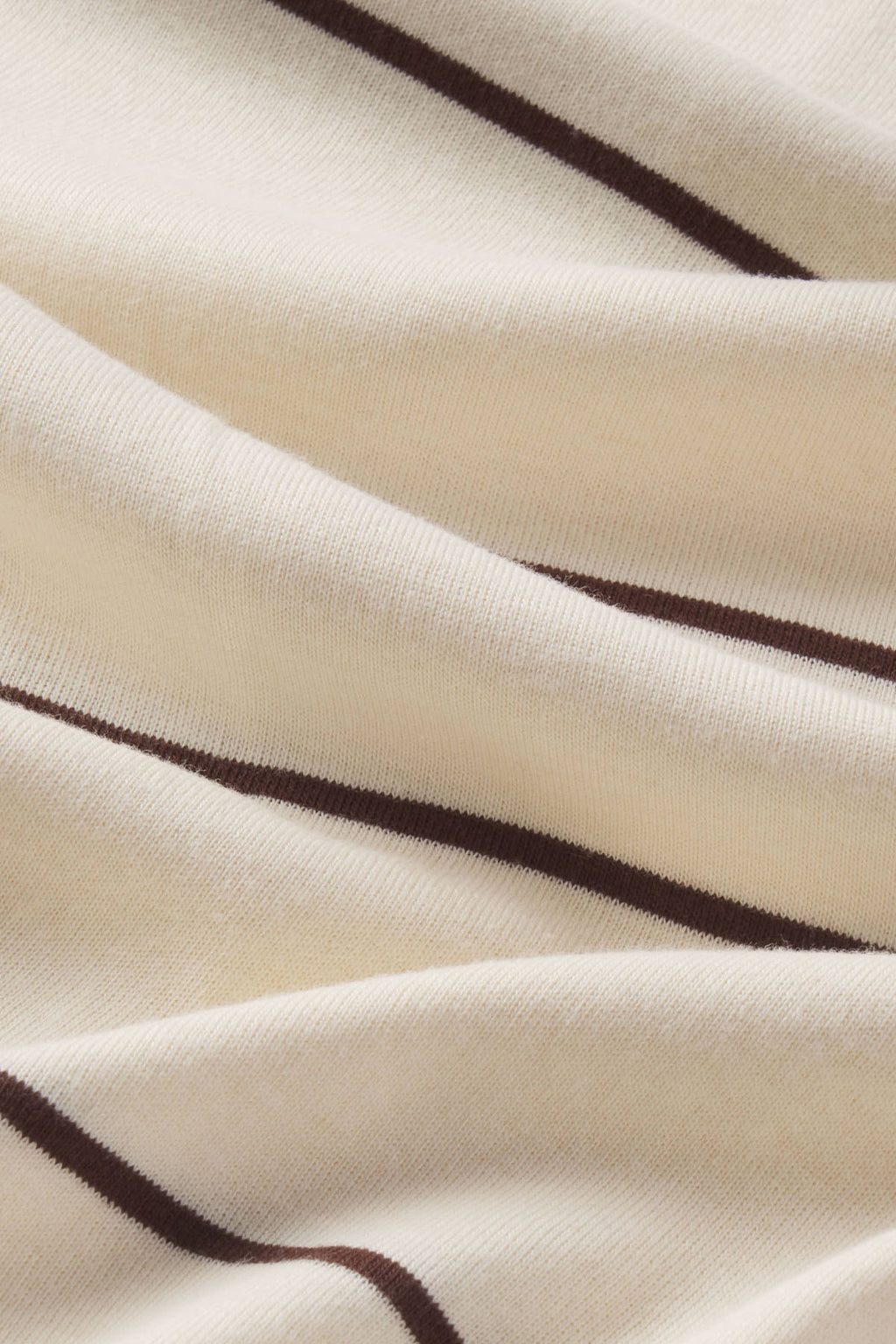 Ribbed knit fabric with alternating cream and brown horizontal stripes.