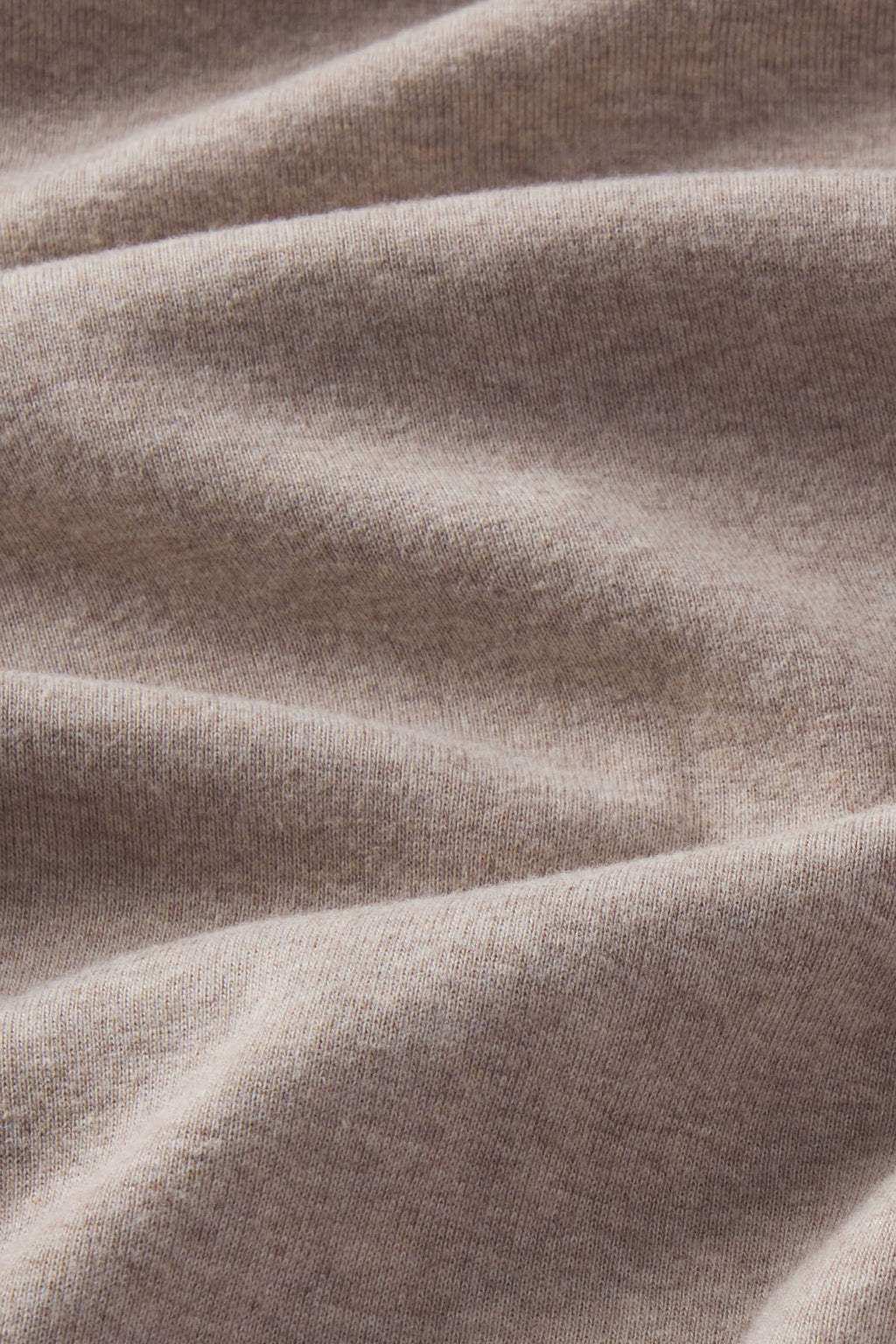 Fawn heather long sleeve tee with ribbed texture and draped fabric folds.