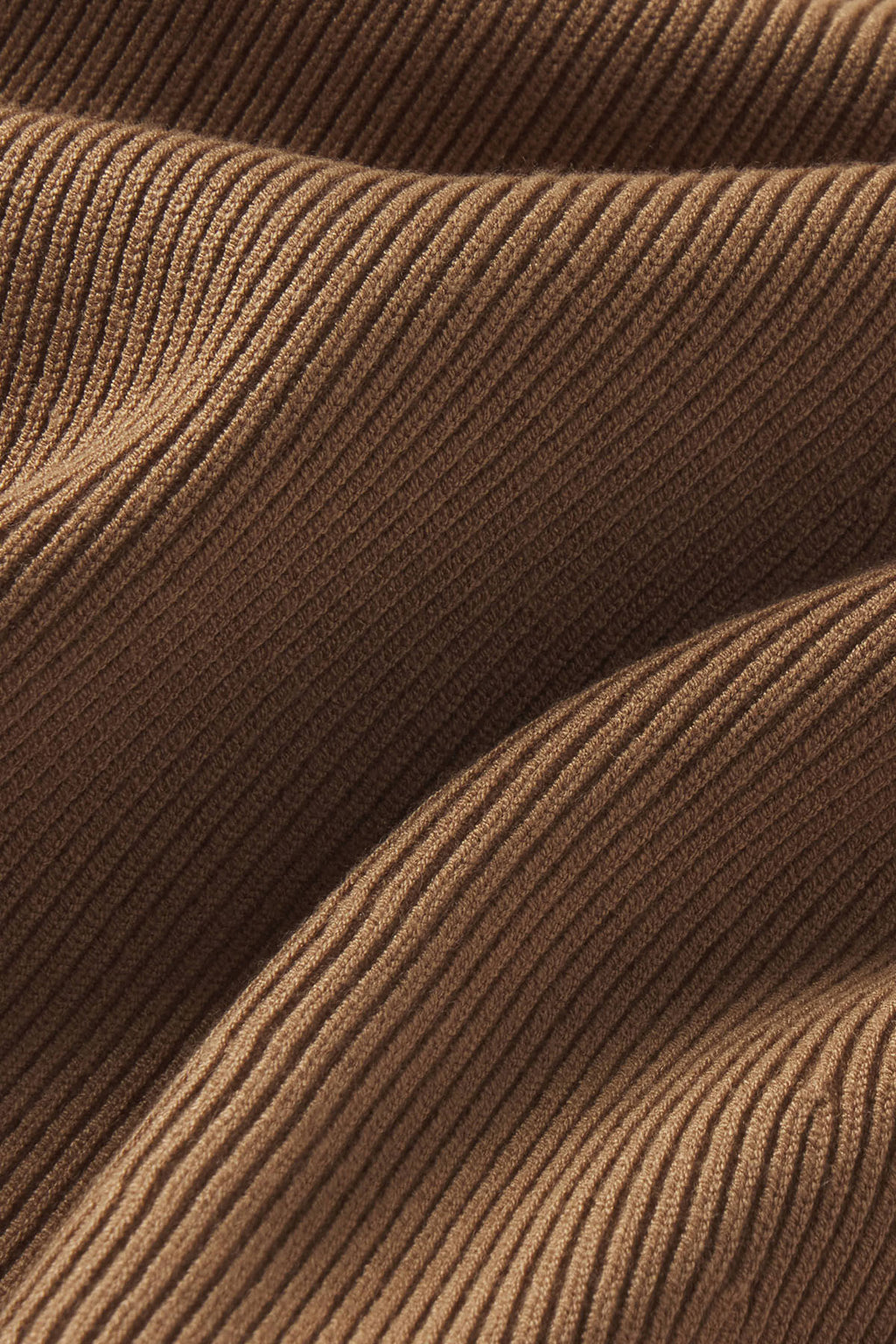 Toffee-colored ribbed knit fabric with vertical texture and draped folds.
