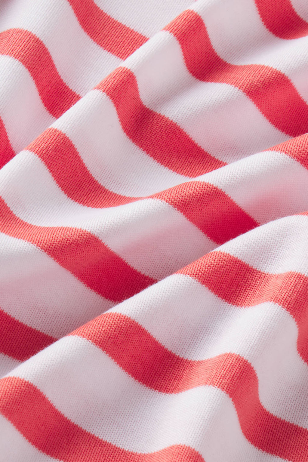 Red and white wavy striped Pima cotton fabric with textured knit surface.