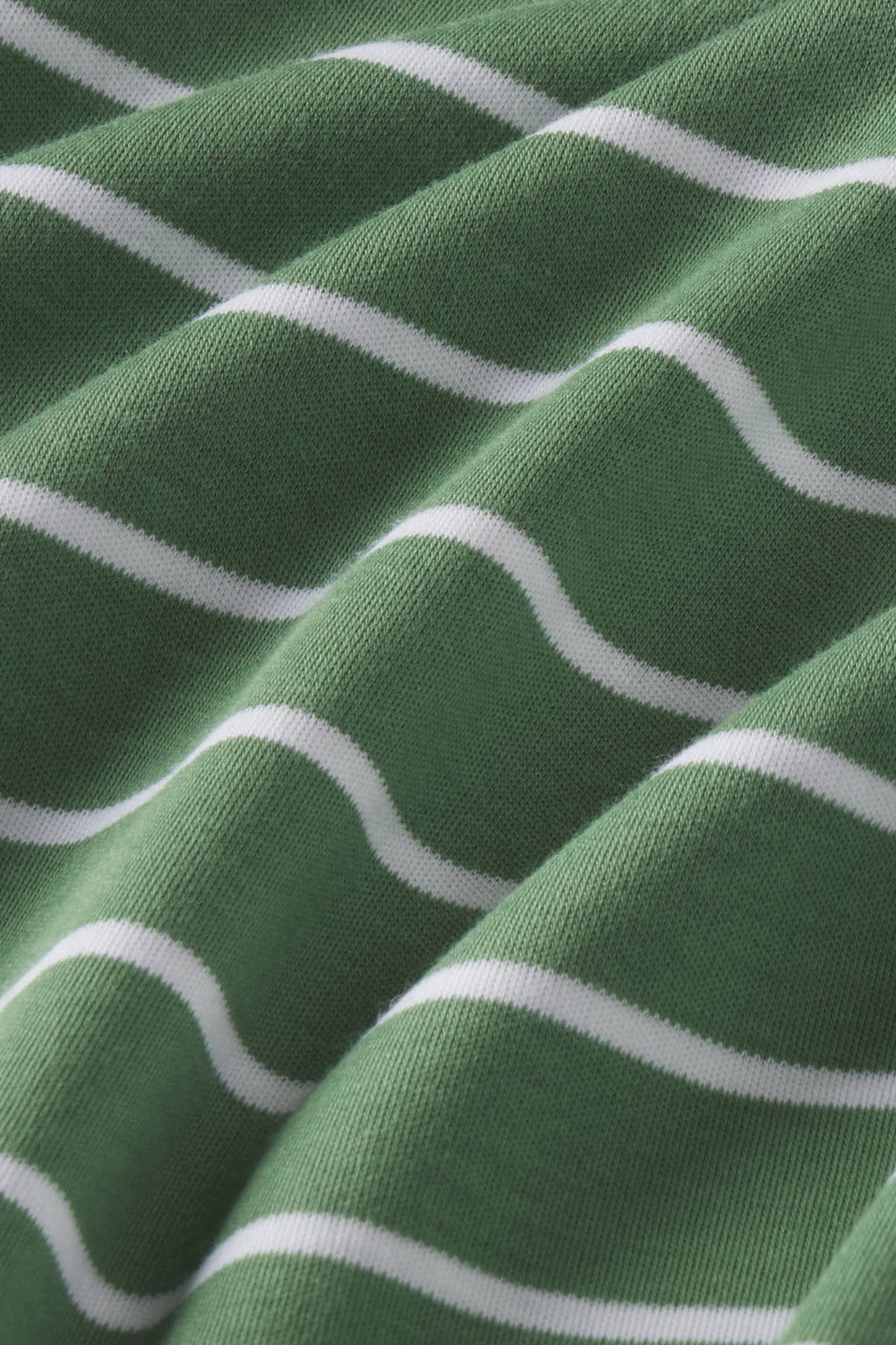 Green and white wavy stripe pattern on ribbed cotton fabric texture.
