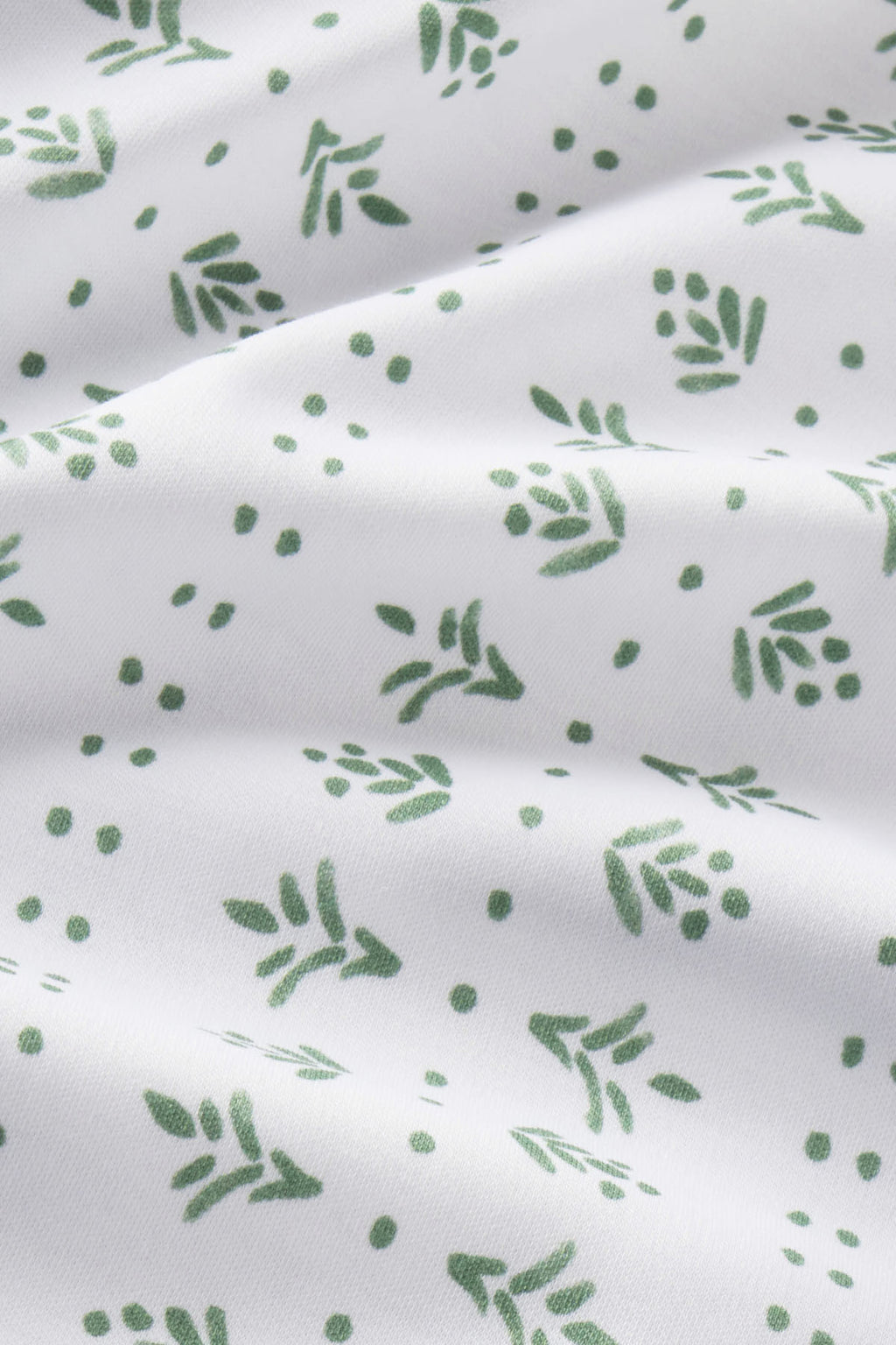White Pima cotton fabric with green leaf and berry print pattern.