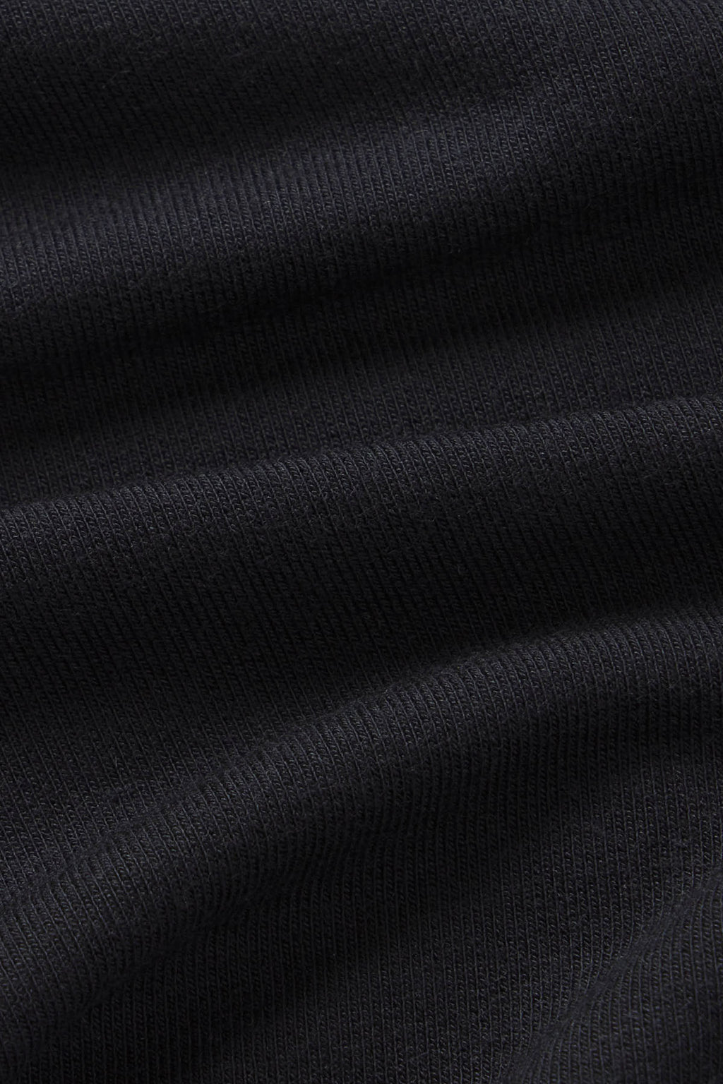 Black ribbed knit fabric with textured surface showing folded layers.