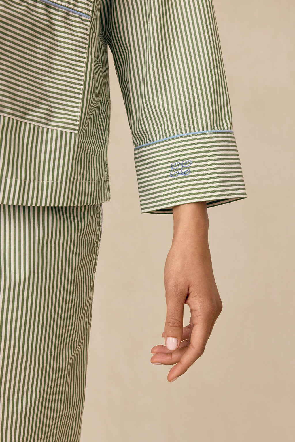 A person wears the Poplin Piped Long-Long Set in Palm Riviera Stripe, featuring green and white vertical stripes, a pocket, blue piping, and relaxed styling against a neutral background.