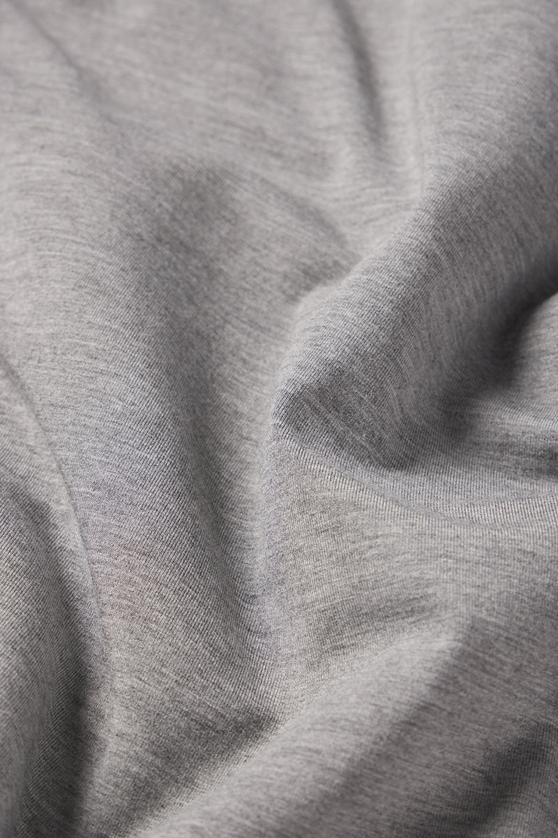 Close-up of the Mens Short Sleeve Bamboo Tee in Heather Gray, showing the soft fabric with visible weave, natural folds, and gentle shadows highlighting its smooth texture.