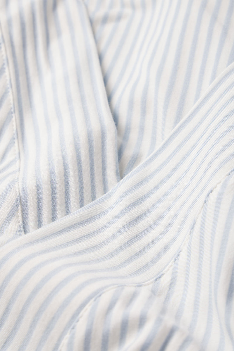 Close-up of the DreamModal Kimono Pajama Set in Fog, featuring light blue and white vertical stripes. Crafted from smooth modal, the fabric shows soft folds and neat seams, offering extra comfort and a nursing-friendly design.