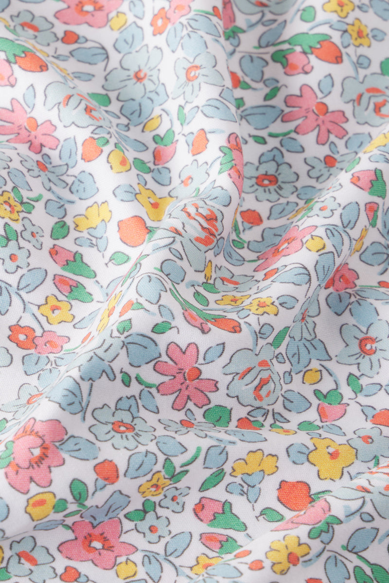 White Pima cotton short robe with multicolored floral print in pink, yellow, orange, and blue tones.