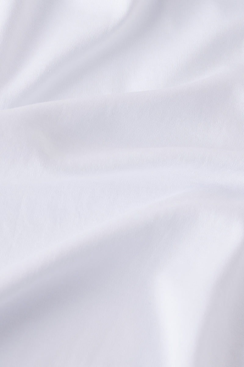 Close-up of soft, white 100% Pima cotton fabric with gentle folds and subtle shadows—ideal for the Pima Ruffle Nightgown in White.