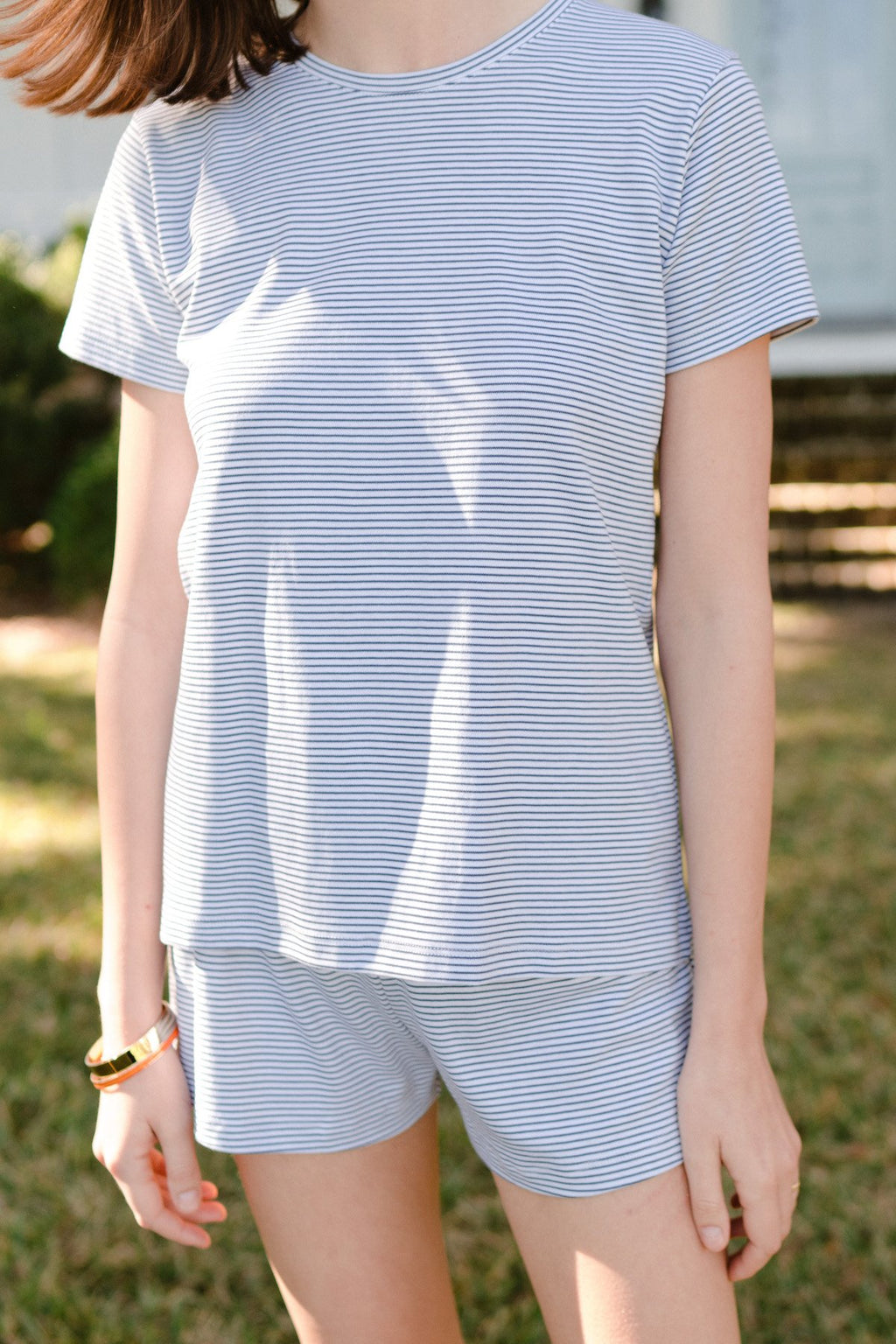 Woman wearing blue and white striped short-sleeve crew neck t-shirt and matching shorts.